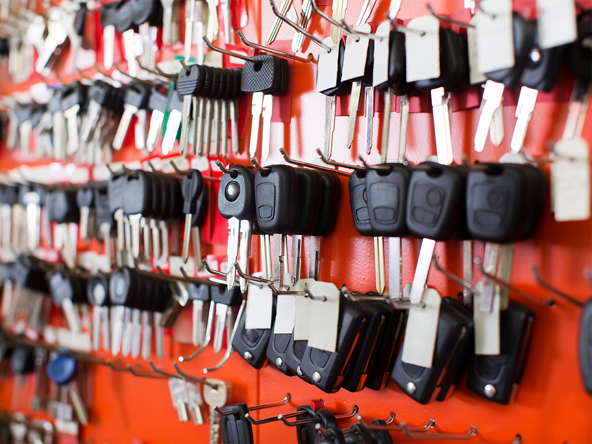 Collection of transponder keys hanging on the wall in a locksmith shop.