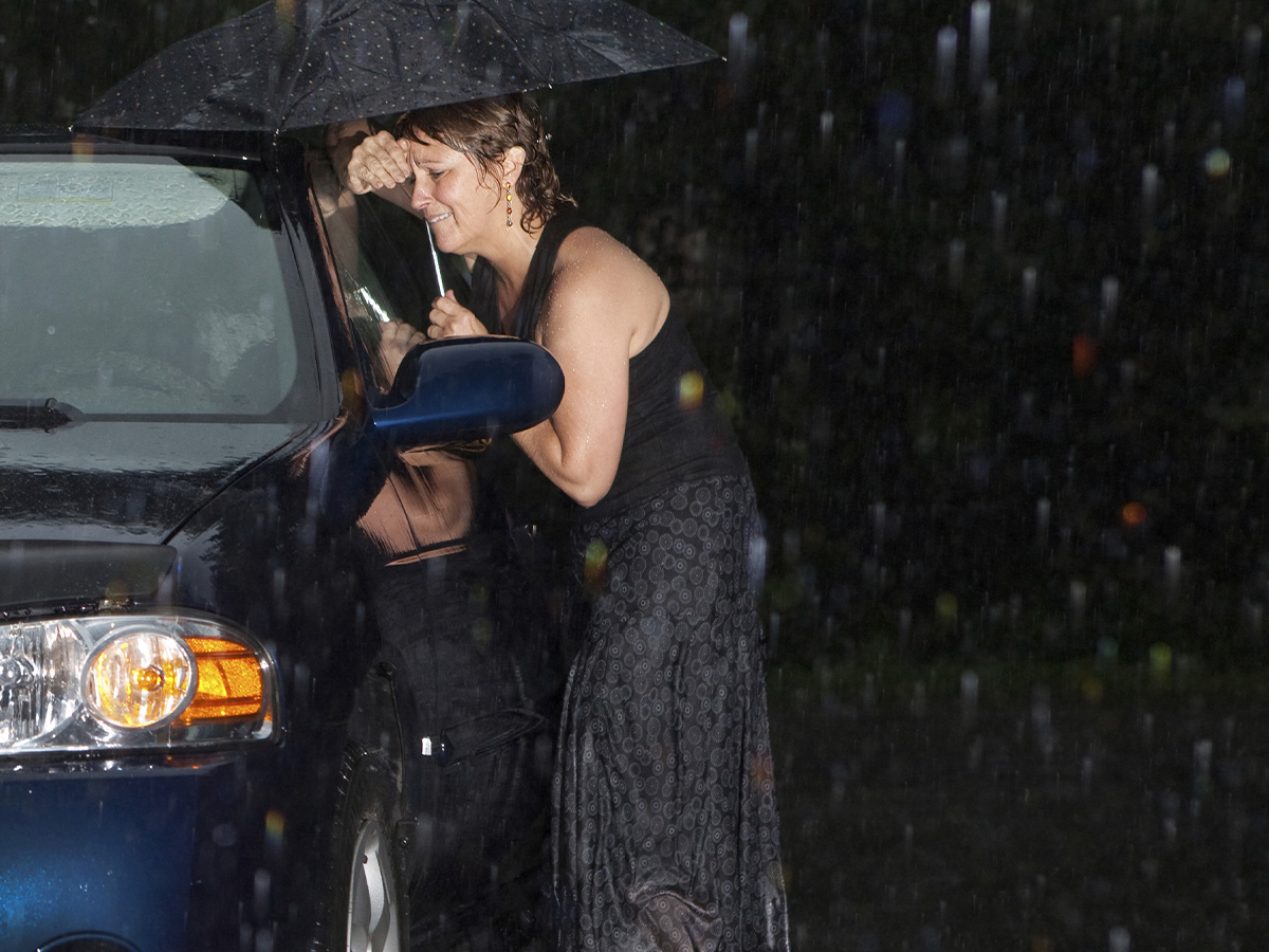 Woman in the rain, locked out of her car at night.