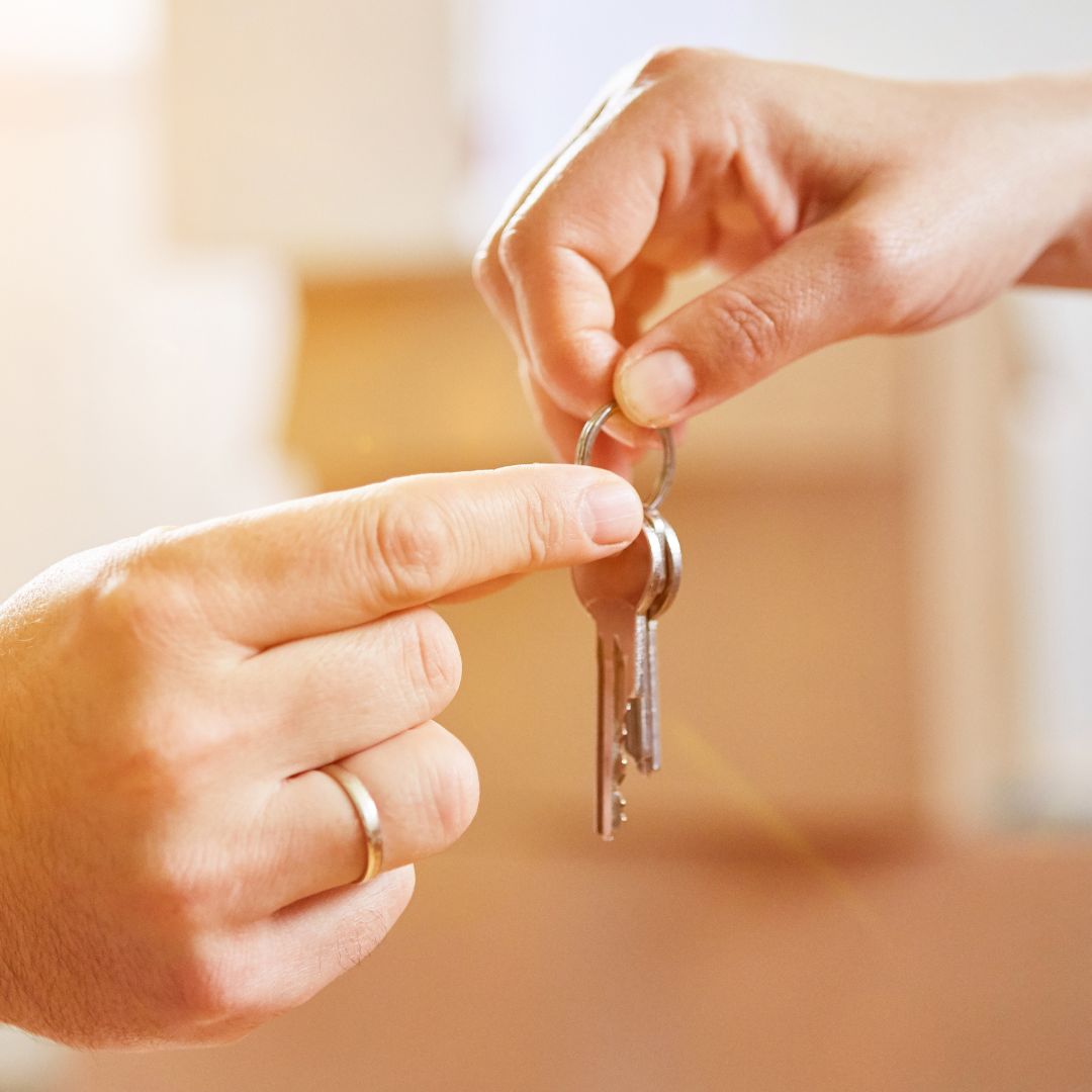 person handing another person keys