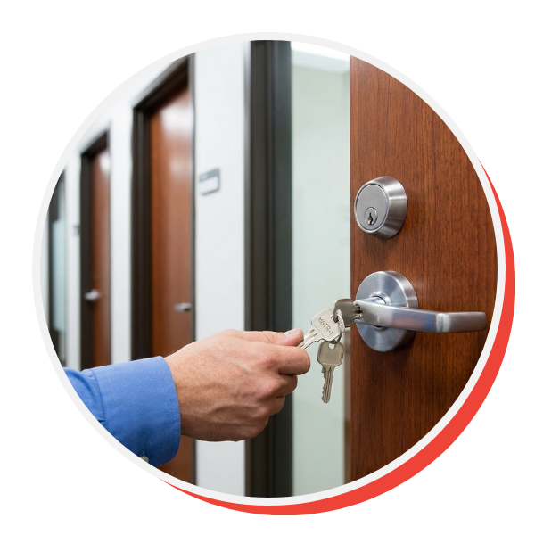 a single 'Master Key' marked 'MSTR-1' inserted into a heavy-duty commercial door lock cylinder with a modern lever handle in a business hallway